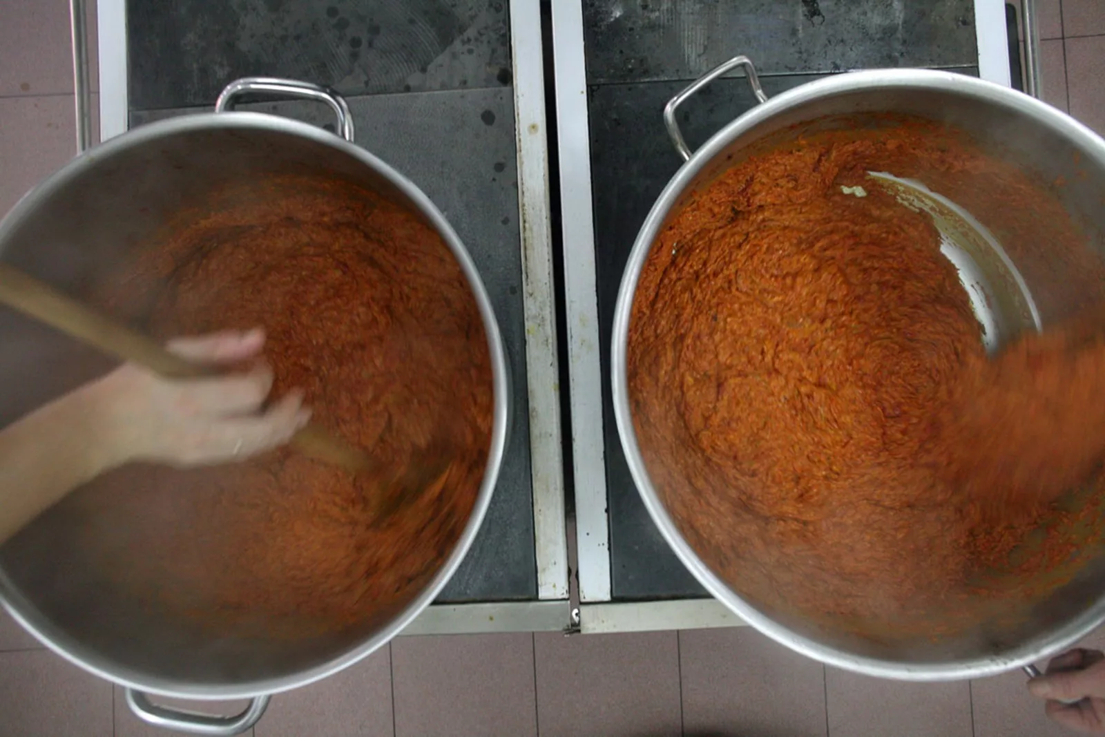 In zwei großen Töpfen wird aus Bio Paprika Ajvar eingekocht.