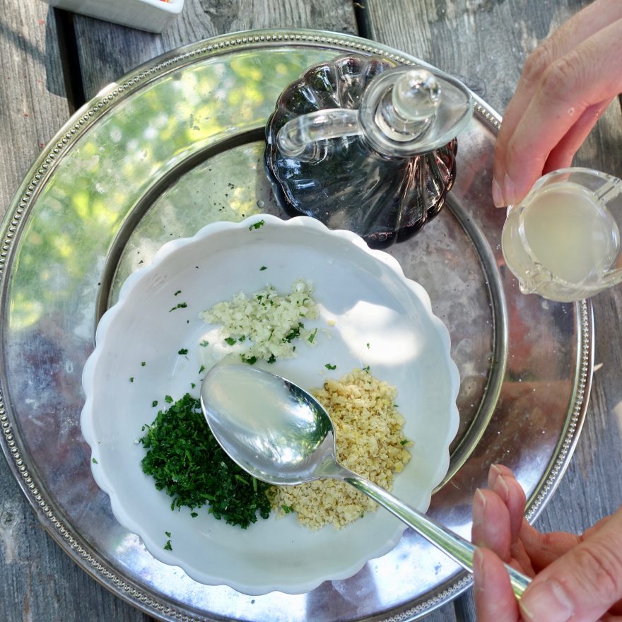 Zitronensaft wird zu den anderen Zutaten für das Ajvar Pesto gegeben.