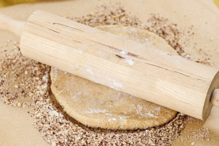 Die Teigkugel wird auf den Nüssen ausgerollt